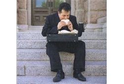 C1 Advanced Speaking Part 2 - A man in a suit sitting on some steps outside a building eating a sandwich with his briefcase on his lap