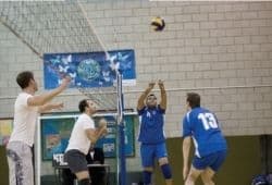 Four people playing volleyball inside - B2 First Speaking Part 2