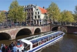 A tour barge on a canal with bridges and European houses - B2 First Speaking Part 2