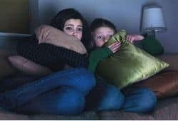 Two people sitting on a sofa watching something scary - B2 First Speaking Part 2