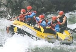 C1 Advanced Speaking Part 2 - People wearing red safety helmets white-water rafting in an inflatable boat