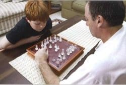A young boy and a man playing chess on a coffee table - B2 First Speaking Part 2