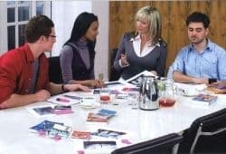Four people sitting around a table discussing something - B2 First Speaking Part 2