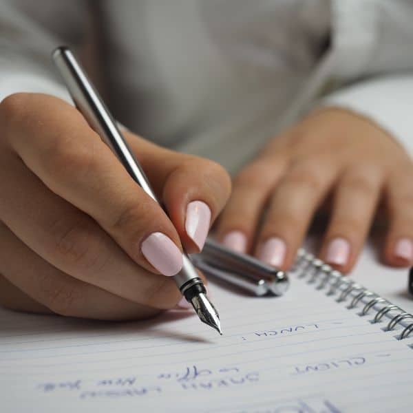 hands writing in a notebook