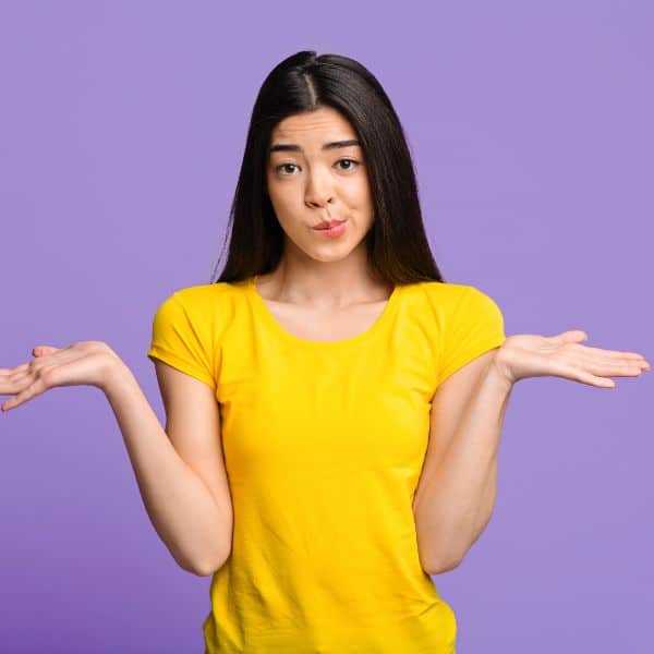 Girl in yellow t-shirt shrugging with purple background