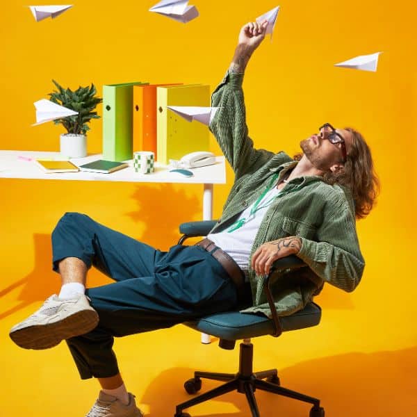 Man leaning back in a swivel chair in yellow room - IELTS Speaking Part 1 Questions