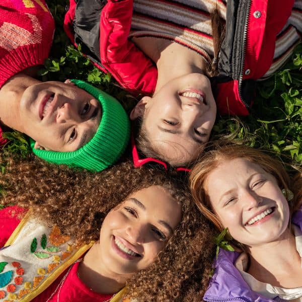 Four young people's smiling faces viewed from above - B2 First Speaking Part 4: 2 Simple Ways To Improve
