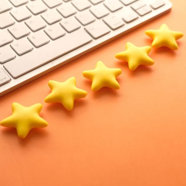A white computer keyboard and 5 gold stars - IELTS Template Sentences for Writing Task 2