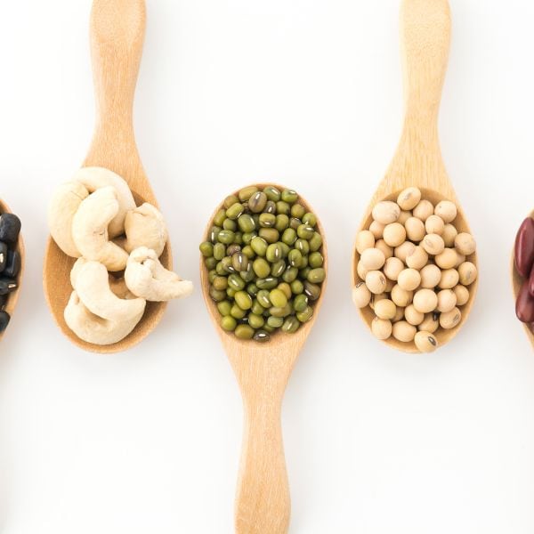 Wooden spoons with various kinds of beans in them against a white background - Topic Vocabulary for B2 First Essays