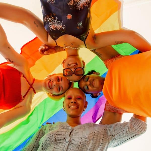 Looking up at four young smiling people in bright clothes - Tone / Formality for Better Letters and Emails – B2 First